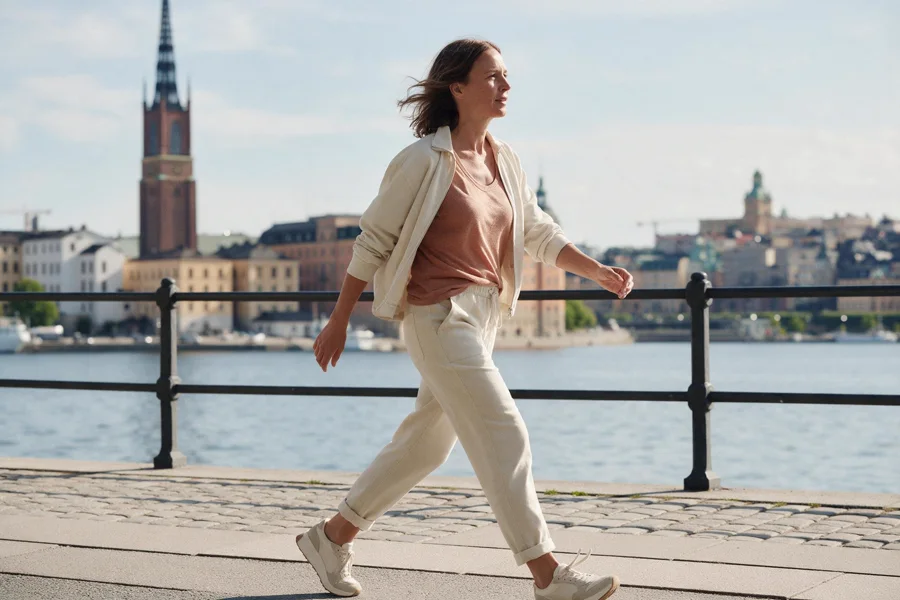 A woman walking briskly along the Stockholm waterfront in the morning